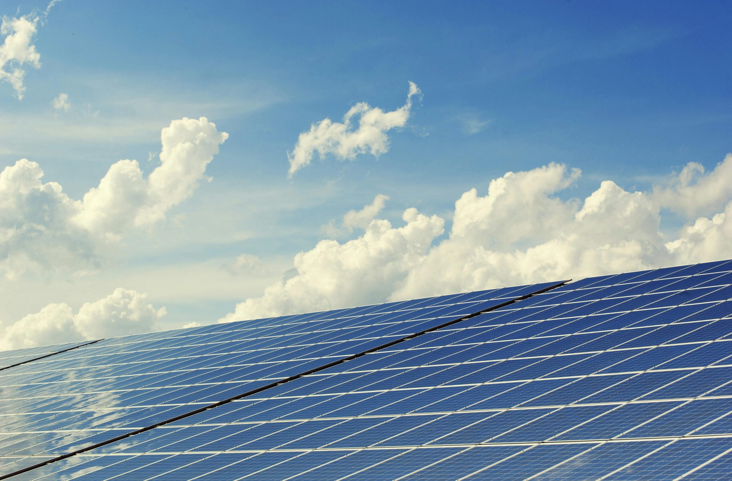 pexels-photo-356036-356036 | Architektura Maharishi Vastu Sleek modern solar panels under a vibrant blue sky with clouds, symbolizing clean energy.